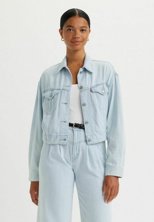 Chaqueta de denim azul claro con un corte cropped, cierre de botones y dos bolsillos en el pecho. Presenta un cuello clásico y una textura suave.