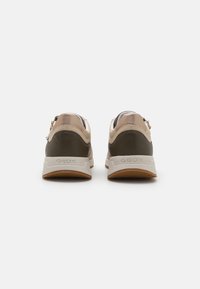 GEOX-sneakers i beige og oliven, med gummisåle, glatte og teksturerte materialer, og subtile detaljer bak.