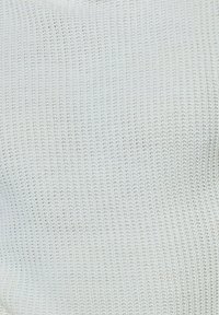 Tissu en tricot blanc avec un motif texturé en côtes. Le matériau est léger et respirant, présentant de petites ouvertures tout au long.