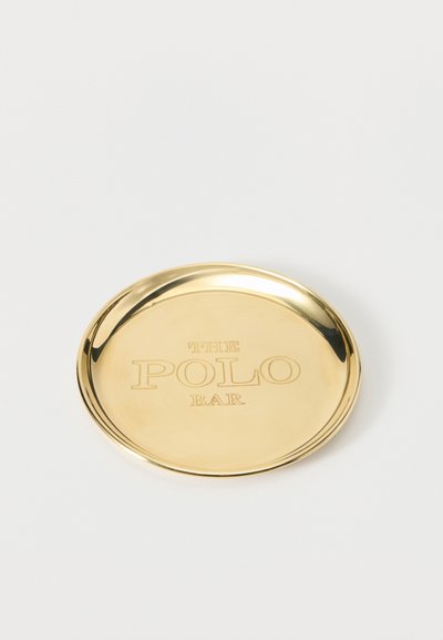 Στρογγυλό λαμπερό χρυσό δίσκο με ανυψωμένα άκρα, χαραγμένο με τις λέξεις "THE POLO BAR" στο κέντρο.