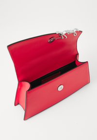Rød skinn clutchveske med en strukturert design, svart interiør, en sølvfarget trykknapplukking og buede kanter for et strømlinjeformet utseende.