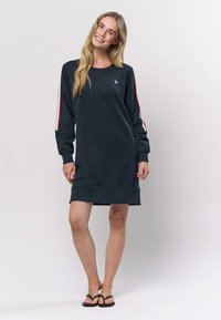 Dunkelgrünes Sweatshirt-Kleid mit langen Ärmeln und roten sowie weißen Streifen an den Ärmeln. Gerippte Bündchen an Ärmeln und Saum. Leichtes, lässiges Design.