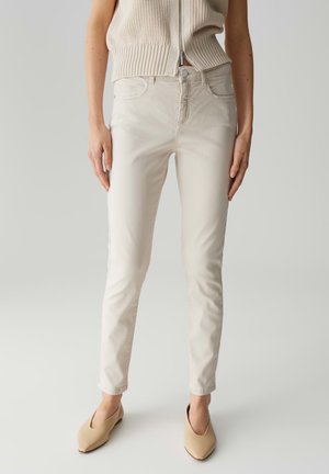 Lichtbeige jeans met een slim fit, voorzien van standaard zakken, een knoopsluiting en subtiele textuur, gecombineerd met nude ballerina's.