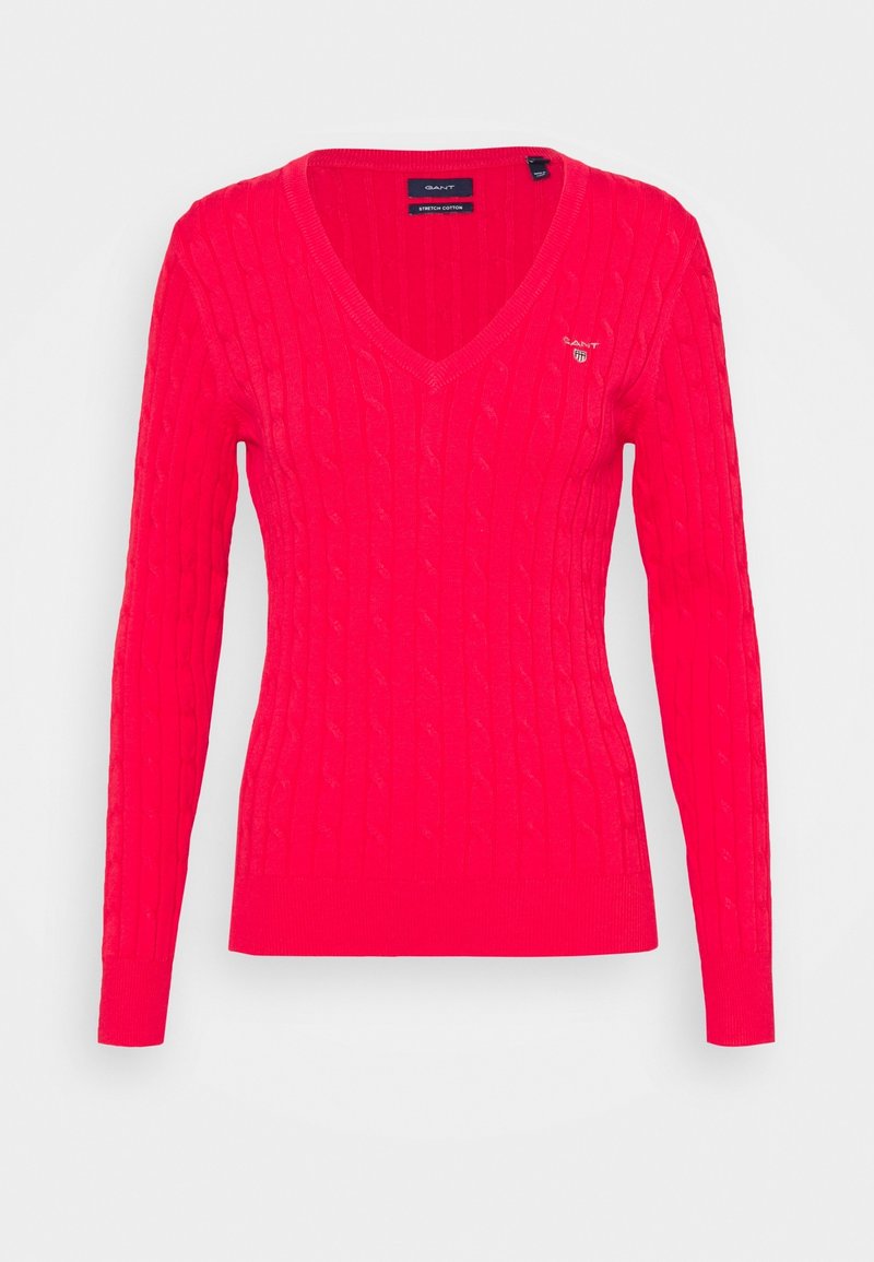 Roter Kabelstrick-Pullover mit V-Ausschnitt und langen Ärmeln. Mit einem Logo auf der linken Brust. Hergestellt aus einem weichen Baumwollgemisch.