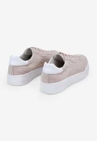 Zapatillas de ante en rosa pálido con detalles en blanco, que presentan una suela de goma gruesa, cordones planos y una lengüeta de talón redondeada.