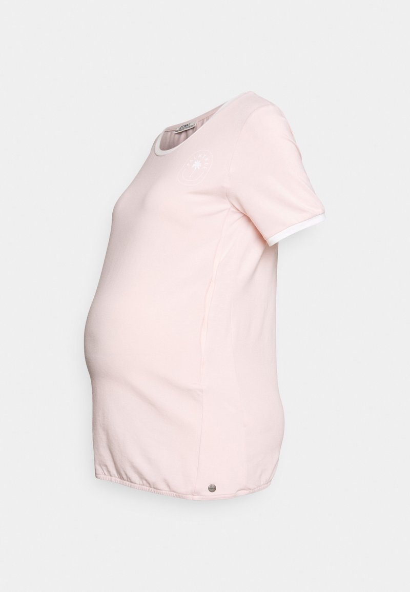 Camiseta de maternidade rosa com mangas curtas, decote redondo e borda branca nas mangas; apresenta um logótipo discreto na parte da frente e uma bainha curvada.