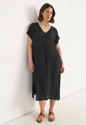 Schwarzes, knielanges Kleid mit V-Ausschnitt, kurzen Ärmeln und komplizierten Spitzenverzierungen auf der Vorderseite; aus leichtem Stoff gefertigt.