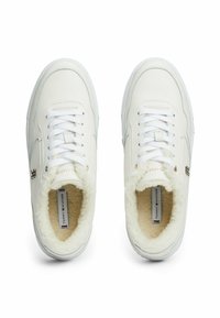 Sneakers bianchi in pelle con una morbida fodera pelosa, punta rotonda, lacci piatti e branding discreto. Design semplice con accenti dorati.