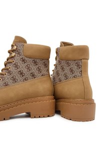 Stivaletti alla caviglia color corda caratterizzati da un tessuto a fantasia marrone testurizzato e una finitura in pelle liscia, con occhielli in tono oro e una suola in gomma spessa.
