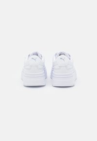 White platform sneakers with a smooth leather upper, rounded toe, and signature logo embossed at the heel, featuring padded collars for comfort.