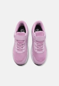 Baskets d'athlétisme roses clair en mesh et matériau synthétique, dotées de lacets, d'une bande Velcro et d'une semelle rembourrée avec un motif texturé.