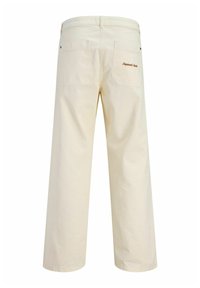 Beżowe jeansy o szerokich nogawkach z dwiema tylnymi kieszeniami, z których jedna ozdobiona jest brązowym haftem "Originals", prezentowane na białym tle.