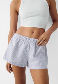 Ljusblå och vita randiga shorts med elastisk midja och knapplås fram, tillverkade av mjukt tyg som ger en avslappnad passform.