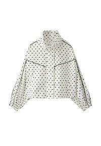 White long-sleeve cropped jacket with black polka dots, high collar, elastic cuffs, and black piping detail on sleeves and chest.