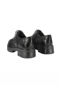 Scarpe in pelle nera con lacci, dalla punta arrotondata, superficie testurizzata e suola in gomma a contrasto, con cuciture decorative e dettagli brogue.