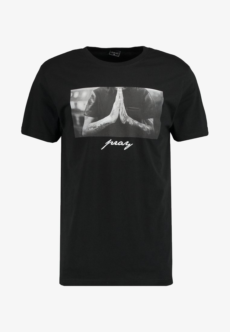 Svart T-shirt med kort ärm som har en central grå grafik av händer i böneställning med texten "pray" under i vitt.