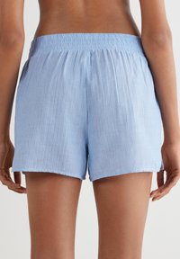 Lichtblauwe katoenen gestreepte shorts met een elastische tailleband. De stof is glad met een lichte textuur en eindigt boven de midden-dij.