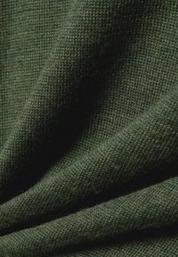 Dark green knitted fabric, featuring a soft texture with visible fibers and a smooth finish, exhibiting subtle variations in shade.