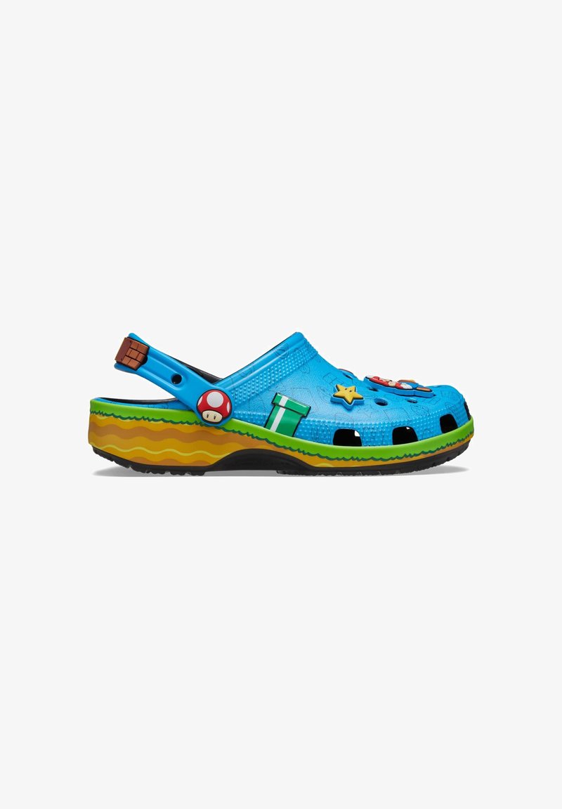 Blue clog with green and yellow sole, decorated with Super Mario themed charms including a mushroom, star, and pipe.