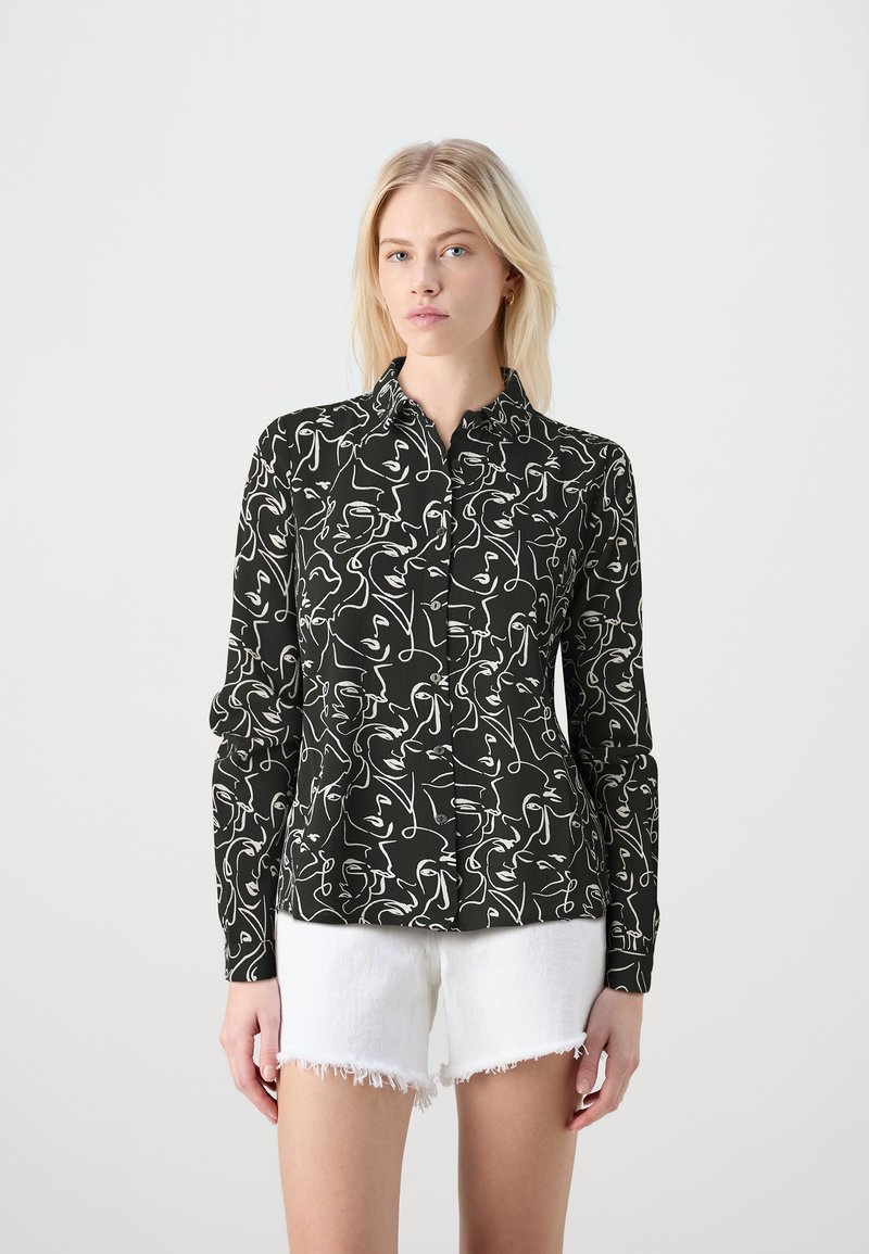 Long-sleeve button-up shirt in black fabric featuring a white abstract line art pattern. Paired with white distressed shorts.