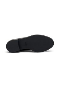 Suela de goma negra de un zapato con textura suave y sin patrones visibles. Marcas en la superficie de la suela para mejorar el agarre.