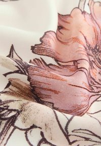 Tessuto leggero con motivo floreale in rosa tenue e marrone su uno sfondo crema, caratterizzato da una superficie liscia e una sottile lucentezza.