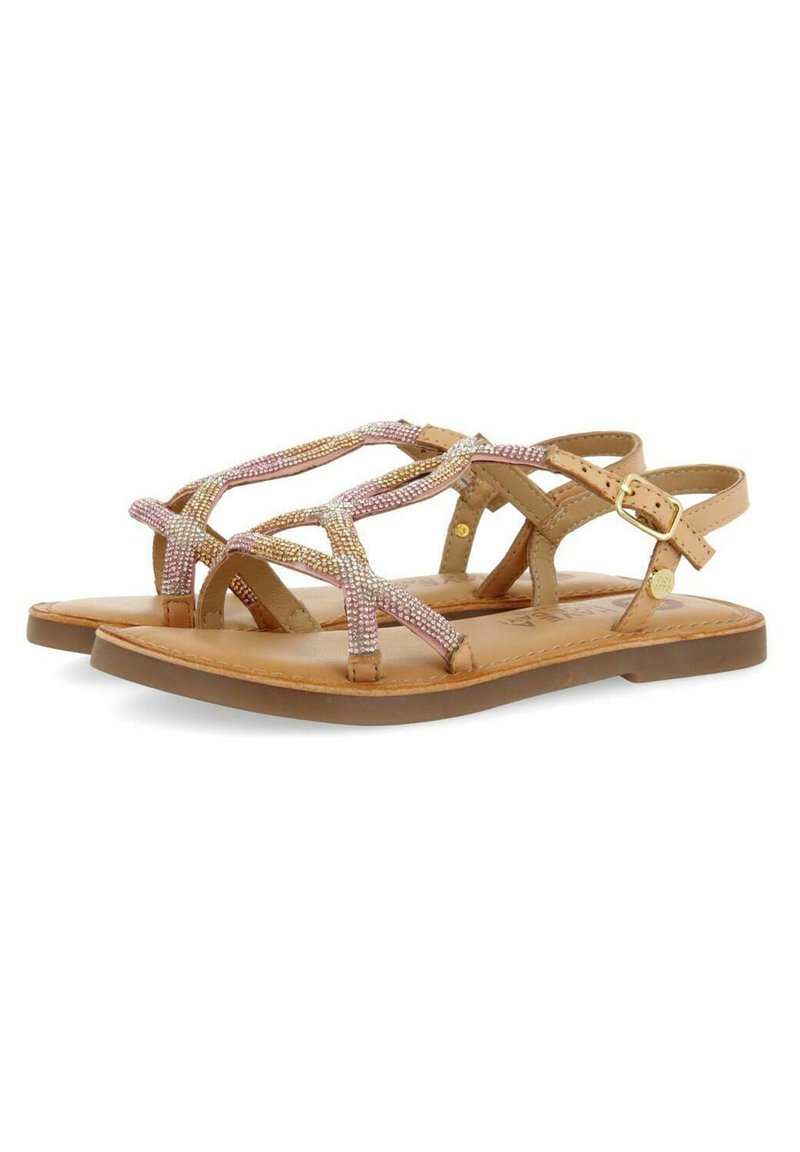 Sandalias planas marrones con un diseño de tiras cruzadas adornadas con detalles en rosa y dorado. Plantillas acolchadas y una correa ajustable en el tobillo.