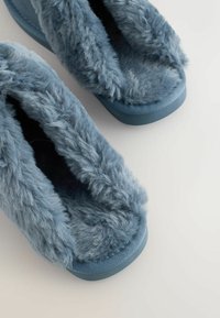 Blauwe, met bont gevoerde slippers met een zachte textuur, een instapmodel en een afgeronde neus. De zool is van blauw rubber voor grip.