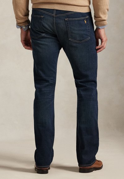 Temno modre kavbojke iz jeansa s pravim krojem, z dvema zadnjima žepoma, vidnimi šivi in subtilnim logotipom na desnem žepu.