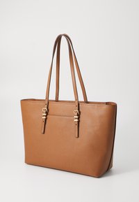 Sac fourre-tout en cuir marron texturé avec deux anses ajustables, quincaillerie dorée et un compartiment zippé à l'avant.