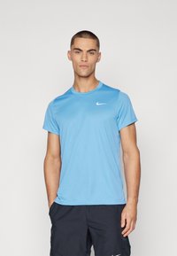 Hele sinine sportlik t-särk, kergest materjalist, lühikeste varrukatega, ümmarguse kaelusega, mille rinnal on väike valge Nike logo.
