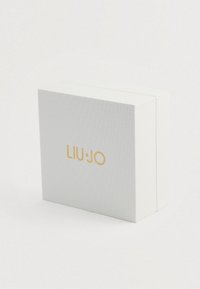 Λευκό κουτί με υφή και χρυσό λογότυπο "LIU JO" στο κέντρο της μπροστινής επιφάνειας, τοποθετημένο σε απλή ανοιχτόχρωμη φόντο.