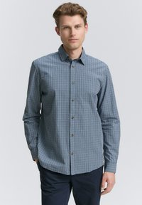 Camisa de manga larga a cuadros en azul marino y blanco, con botones en la parte delantera y un collar clásico. Tejido de algodón, corte relajado.