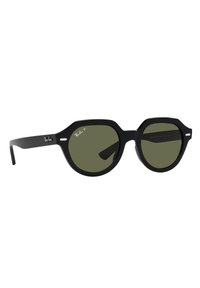Occhiali da sole neri, ottagonali, con lenti oscurate di verde. Presentano una montatura nera elegante e un discreto logo Ray-Ban sulla stanghetta.