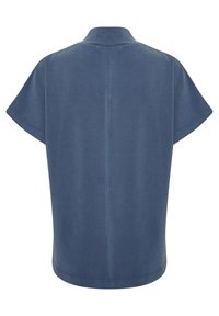 Kortärmad, blå topp med krage. Slät textur, avslappnad passform. Har en rak bakseam och böjd fåll.