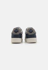Marina lädersneakers med grå mocka-HEEL accenter, vita gummisålar och logotyp bak. Slät textur med en klassisk högskärning design.