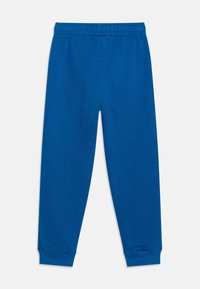 Blå bomullssweatpants med elastisk midja, tapered muddar och slät yta. Inga synliga mönster eller ytterligare designelement.