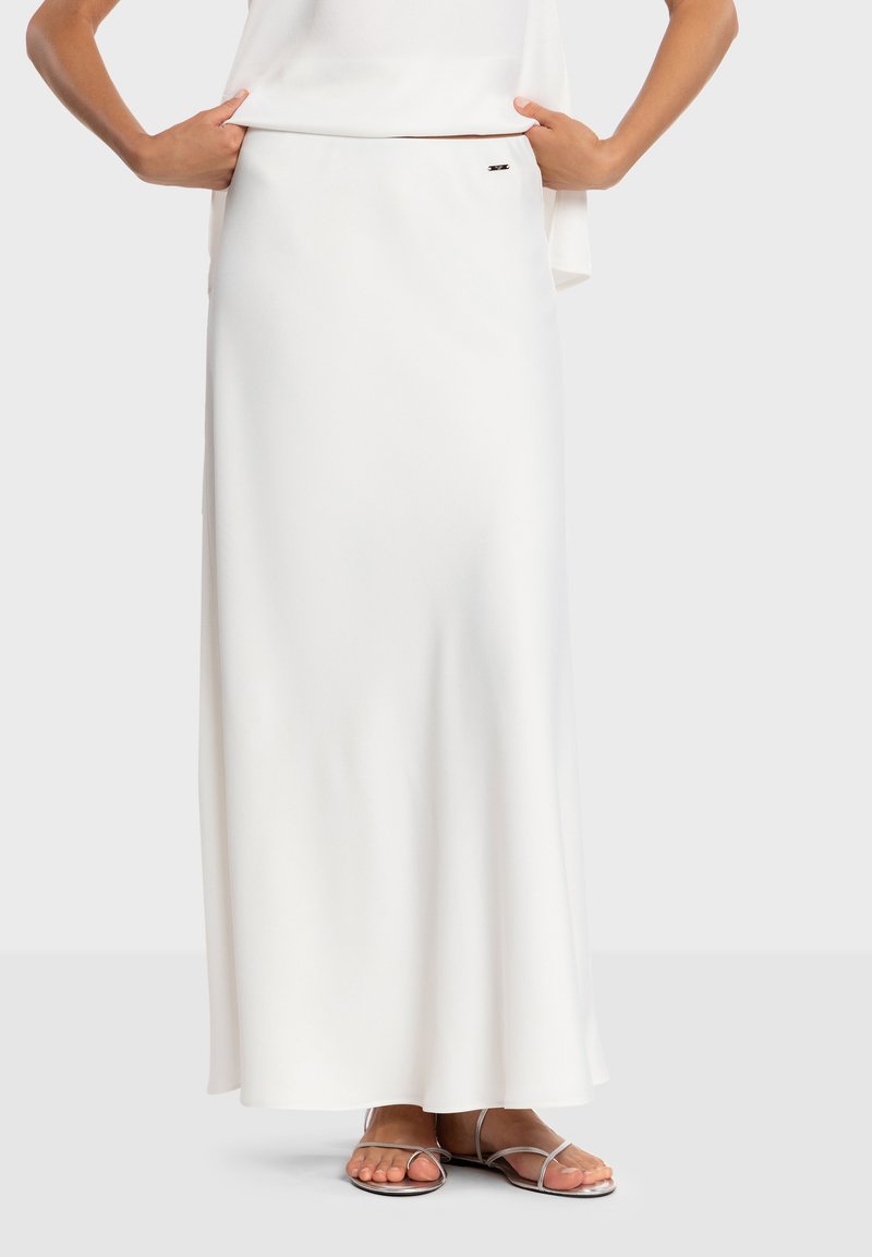 Jupe maxi blanche en tissu fluide à la texture lisse, dotée d'un discret logo sur la ceinture et d'une silhouette droite.