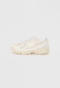 Baskets de sport beige clair avec tige en mesh, accents blancs, bout rond, profil bas et semelle en caoutchouc texturé. Les lacets sont blancs.