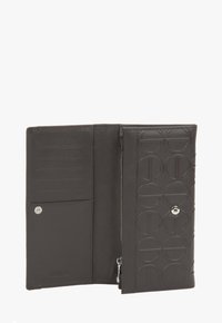 Czarny skórzany portfel, z wytłoczonym okrągłym wzorem, wnętrzem z kieszeniami na karty, kieszonką na zamek i zapięciem na zatrzask. Gładka faktura.