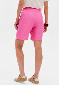 Roze op maat gemaakte shorts met een rechte pasvorm, voorzien van een medium hoge taille en zijzakken. Draag ze met beige, instap, textuur schoenen.