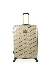 Maleta rígida en color beige con un estampado negro del logo de DKNY. Cuenta con un mango retráctil, herrajes dorados y cuatro ruedas giratorias para mayor movilidad.