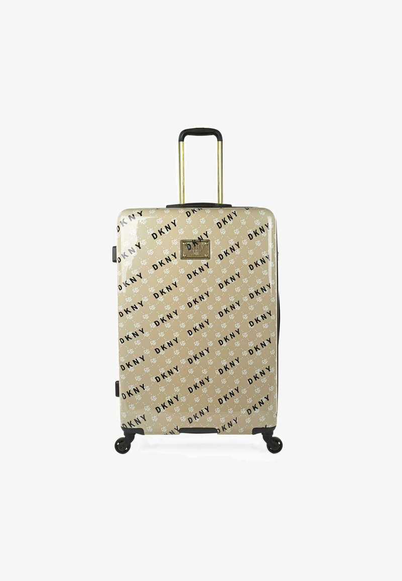 Maleta rígida en color beige con un estampado negro del logo de DKNY. Cuenta con un mango retráctil, herrajes dorados y cuatro ruedas giratorias para mayor movilidad.