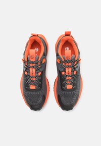 Schwarze und orange Sport Schuhe verfügen über ein Obermaterial aus Mesh, einen gepolsterten Kragen, orangefarbene Akzente und strapazierfähige Schnürsenkel mit einer strukturierten Sohle für besseren Halt.