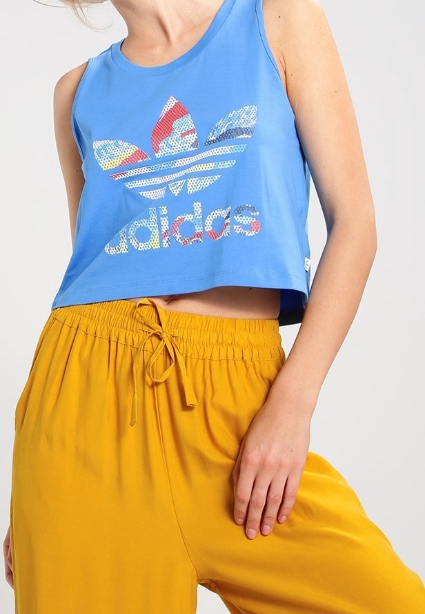 Blå kortärmad tanktopp med en färgglad Adidas-logotyp; har rund hals och är utan ärmar, kombinerad med gula byxor med elastisk midja.