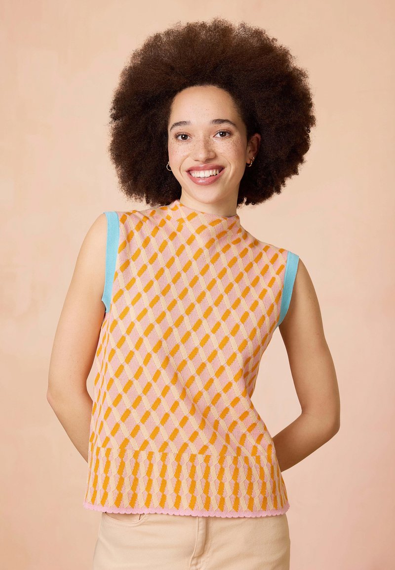 Mouwloze gebreide top met een geometrisch patroon van oranje en roze diamanten, lichtblauwe accenten op de schouders en een gegolfde zoom.