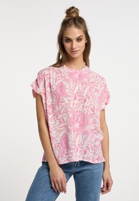 Top leggero a maniche corte di colore rosa pallido con un intricato motivo paisley di rosa scuro. Collo rotondo e vestibilità ampia. Tessuto morbido e traspirante.