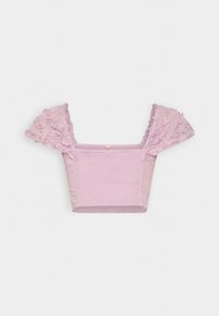 Rosa kort topp med volangärmar och figursydd bodice. Tillverkad av lätt tyg med en slät textur och rena kanter.