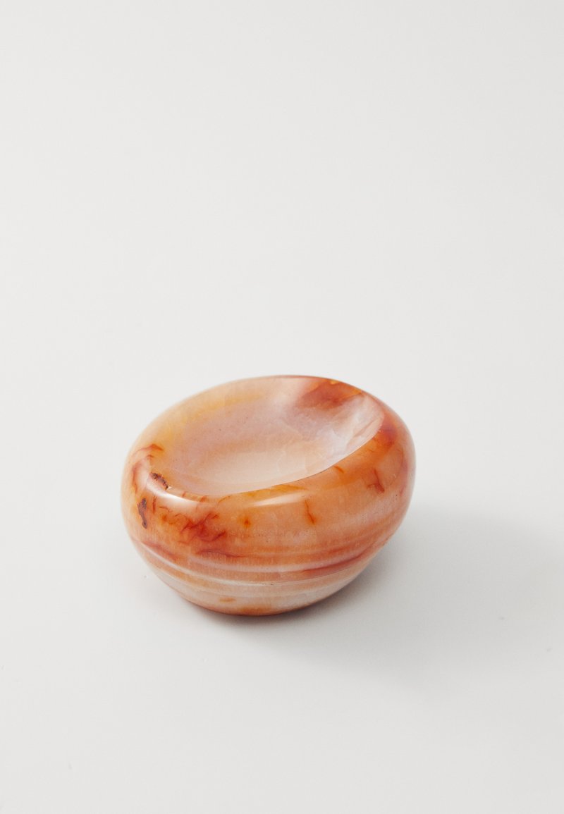 Rund steinbolle i gjennomsiktige ferskenfarger med subtile oransje årer; blankfinish og en glatt, polert overflate.