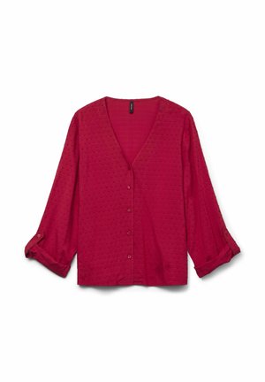 Blusa rossa a maniche lunghe con scollo a V, maniche arrotolate fino al gomito, tessuto texturizzato con un motivo a pois, vestibilità casual.